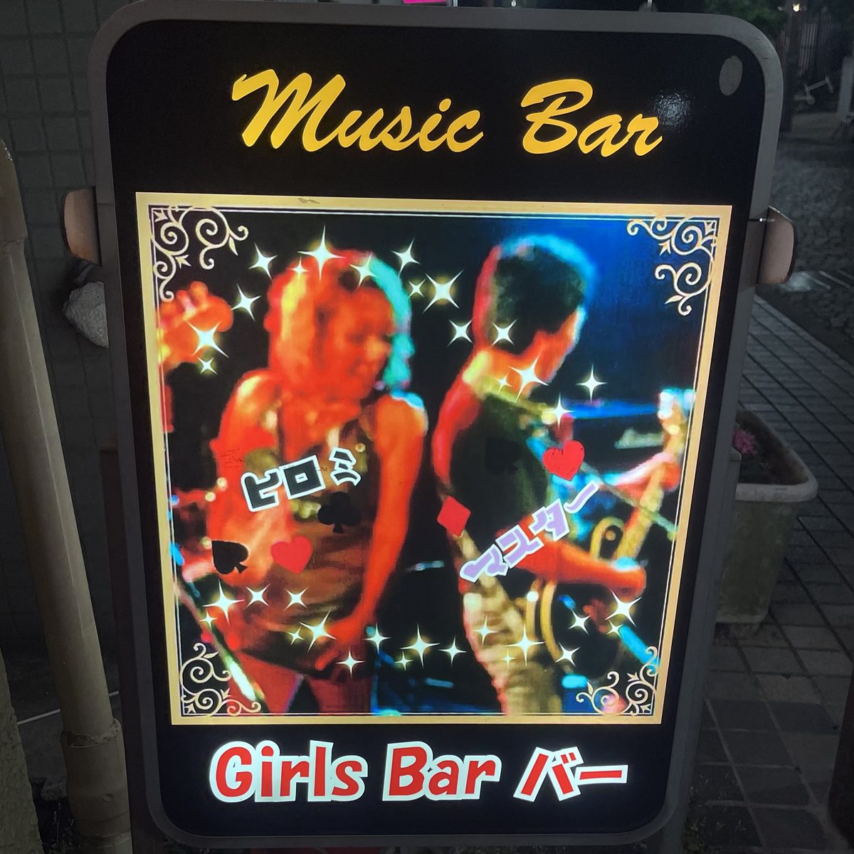 Music Bar / Girls Bar バーの店頭看板。ヒロミとマスターの写真入り